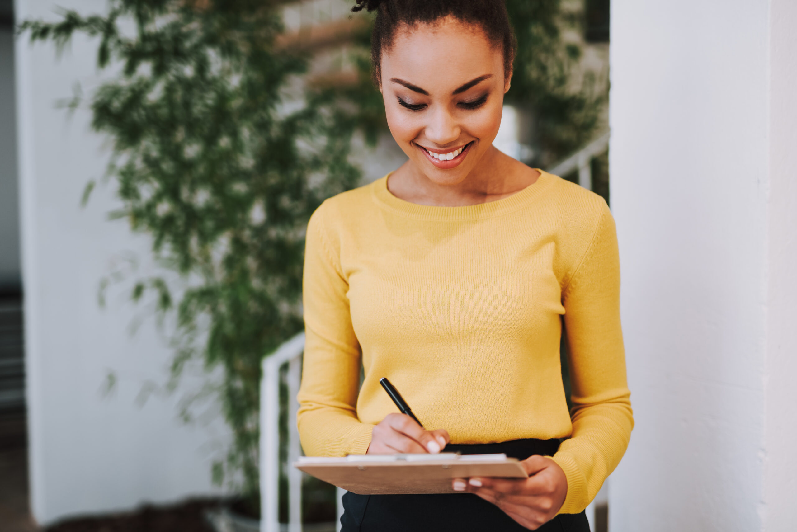 Woman writing in notebook to create a corporate event planning checklist